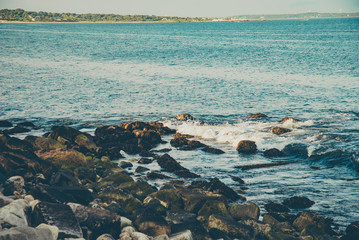 Obraz premium Rhode Island ocean rocks at sunset