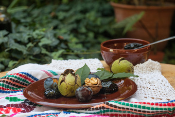Fresh and dried prunes on plate.