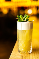 Close-up cocktail  with dried lime and mint on the bar, blurred background.