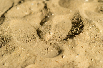 shoes on foot print on sand beach