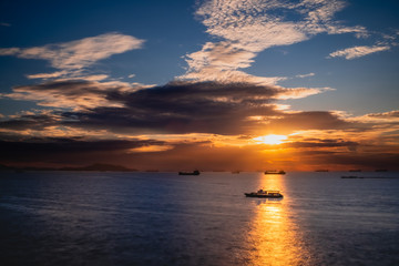 Naklejka na ściany i meble the silhouette boat on the beautiful sea at sunset