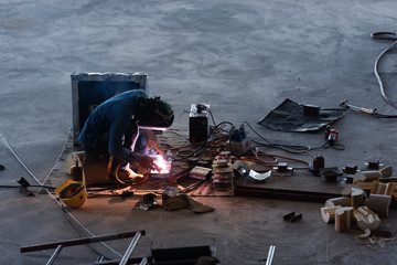 Welding steel pipe or welder in the factory building. Unsafe and dirty industrial work.