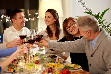 celebration, holidays and people concept - happy family having dinner party, drinking red wine and toasting at home