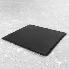 square plate on table. black dish on gray cement background. copy space