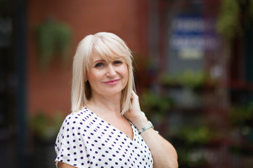 Portret happy Elegant middle aged woman  walks down the street in summer day. positive. positive. happy lifestyle concept