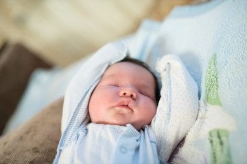 newborn baby sleeps with arms raised. A two week old baby boy, fast asleep with his arms raised.