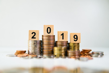 Wooden block year 2019 with pile of coins using as business planning and financial concept