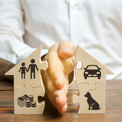 A man shares a house with his palm with images of property, children and pets. Divorce concept,...