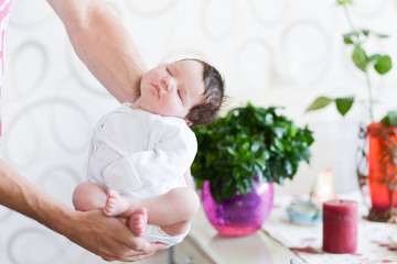 Obraz na płótnie Canvas Newborn baby in hands. Adult Hands holding newborn baby with white background.