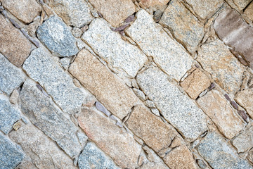 Detail of an old stone wall arranged in an irregular manner. Architecture constructions. Vintage background. Oblique lines.