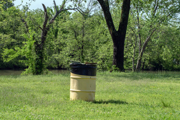 A trash barrel at the lake is an important part of keeping the area clean and tidy in Oklahoma. Bokeh.
