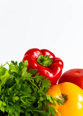 fresh ripe vegetables on a white background: bell pepper, parsley, pink and yellow tomatoes