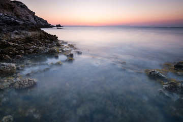 Fototapeta na wymiar Long Exposure Sunrise over Rocky Cliffs at Sea,Greece