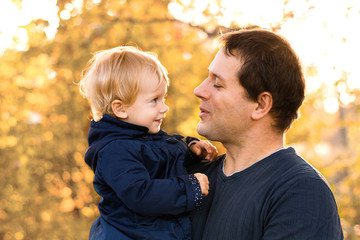 Father and daughter in blue clothes in yellow autumn forest