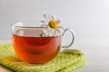 tea in a mug with berries and chamomile on a white background