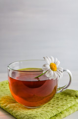 tea in a mug with berries and chamomile on a white background