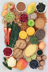 Super food concept for a high fibre vegan diet with fruit, vegetables, whole grain rolls, whole wheat pasta, nuts,  grains, seeds and spirulina powder. High in antioxidants, anthocyanins & vitamins.