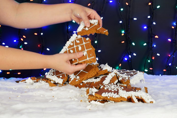 The crashed hand-made eatable gingerbread house, snow decoration, garland background illumination - 282291615