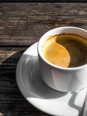 cup of coffe, image shape from shadow Yin Yang, on wooden background. White ceramic cup, stylish toning, copy space