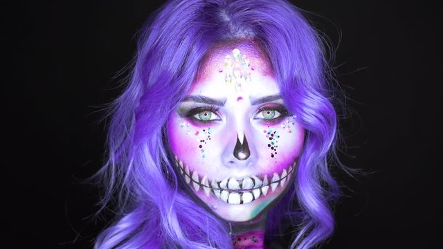 formidable woman with white face and bright blue purple hair, vivid colorful contrasting image of sweet sugar skull in pink and indigo hair, Mexican goddess of death Katrina, games with dark magic