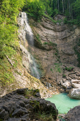 Waterfall streams down in a beautiful small blue lake in Tirol, Austria