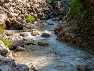 Griessbach Gorge in Erpfendorf, Tyrol alps, Austria - wild stream running over stones, wild water