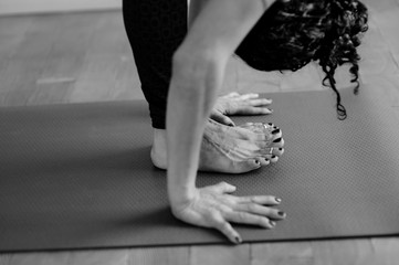 Woman practicing yoga full forward bend touching the mat. 
