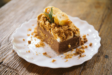 Banana caramel and hazelnut cake close up on wood table 