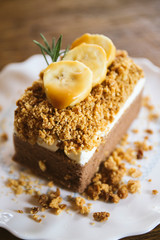 Banana caramel and hazelnut cake close up on wood table 