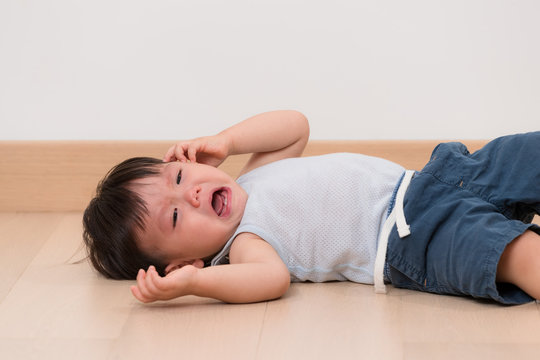 Asian little boy cry and lying on floor