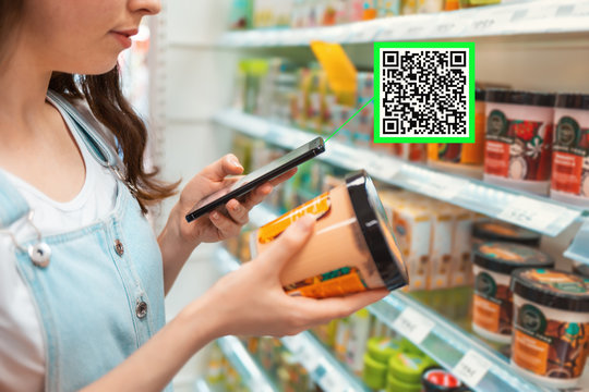 Shopping. Young Woman Scans Qrcode Of The Body Cream. Modern Technology In Everyday Life. Close Up