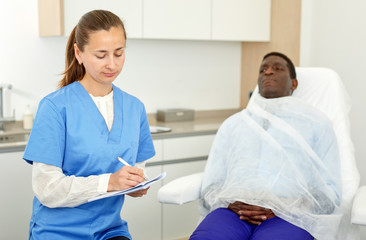 Obraz premium Cosmetician female signing papers before aesthetic facial procedure with man