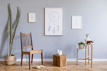 Stylish bohemian interior design of living room with retro chair, wooden cube, flowers , tropical leaf, mock up poster frames, flowerbed, basket and elegant accessories. Modern home decor. Template.