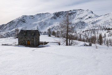 stone mountain refuge in a snowy landscape