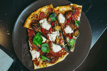 A piece of freshly baked homemade vegetarian pizza cuts with mussels tomatos tofu close up