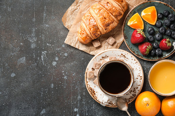 Breakfast with croissant, coffee, orange juice and berries