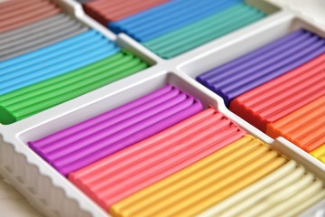 Multicolored briquettes of soft plasticine for modeling with soft focus. Plastic colorful material for kids art education. Set of rainbow plasticine for handmade model. Soft plastic molding mass. 