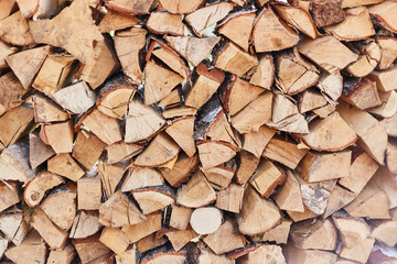 Firewood round stacked under the wall. A pile of wooden logs.