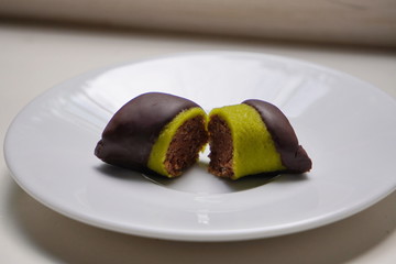 candy, pistachio in chocolate lying on white plate, healthy sweets