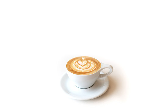 A cup of latte or capuchino in a white cup on white surface