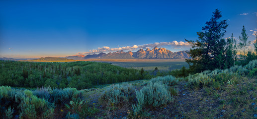 Panoramic view of early sun rays on the Grand Teton mountain range. - obrazy, fototapety, plakaty