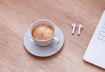 Coffee, laptop and headphones on wooden table. Relax concept