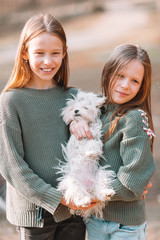 Little girls with a white puppy. A puppy in the hands of a girls