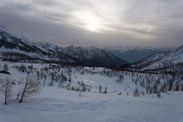Fototapeta na wymiar Snowy panorama of the Val Bognanco that opens behind Domodossola at the dawn, Piedmont