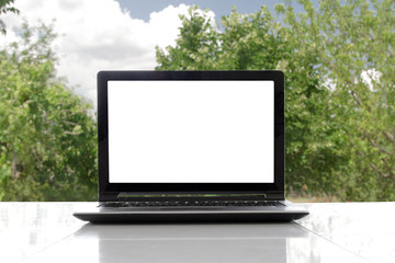 Laptop with blank screen in the garden