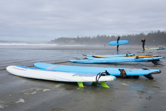 Surf boards at the beach of tofino on Vancouver island on a stormy rainy day