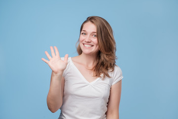 woman smiling happily, saying Hello, Hi or Bye