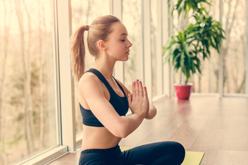 Fototapeta na wymiar Young female meditating in gym