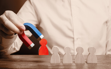 The businessman draws a red figure from the team with a magnet. Increase team efficiency and...