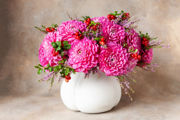 Beautiful fresh bouquet of pink dahlias in white vase.